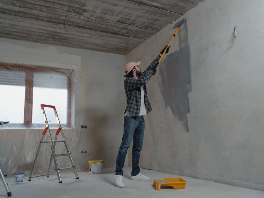 A professional painter rolling fresh paint onto a wall — local home-service work