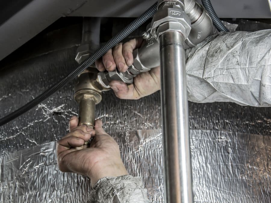 A plumber installing pipe fittings — local home-service work